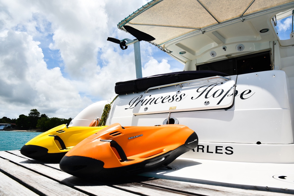Yellow and orange jet skis beside yacht 'Princess Hope'