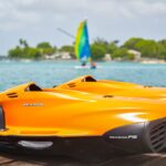 Two orange Seadoo jet skis on a tropical dock