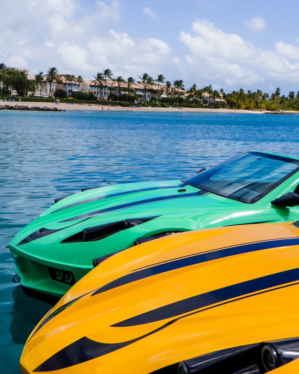 Colorful speedboats on tropical blue water near palm trees