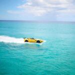 Yellow sports car floating on blue ocean water