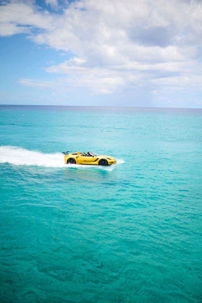 Yellow sports car floating on blue ocean water
