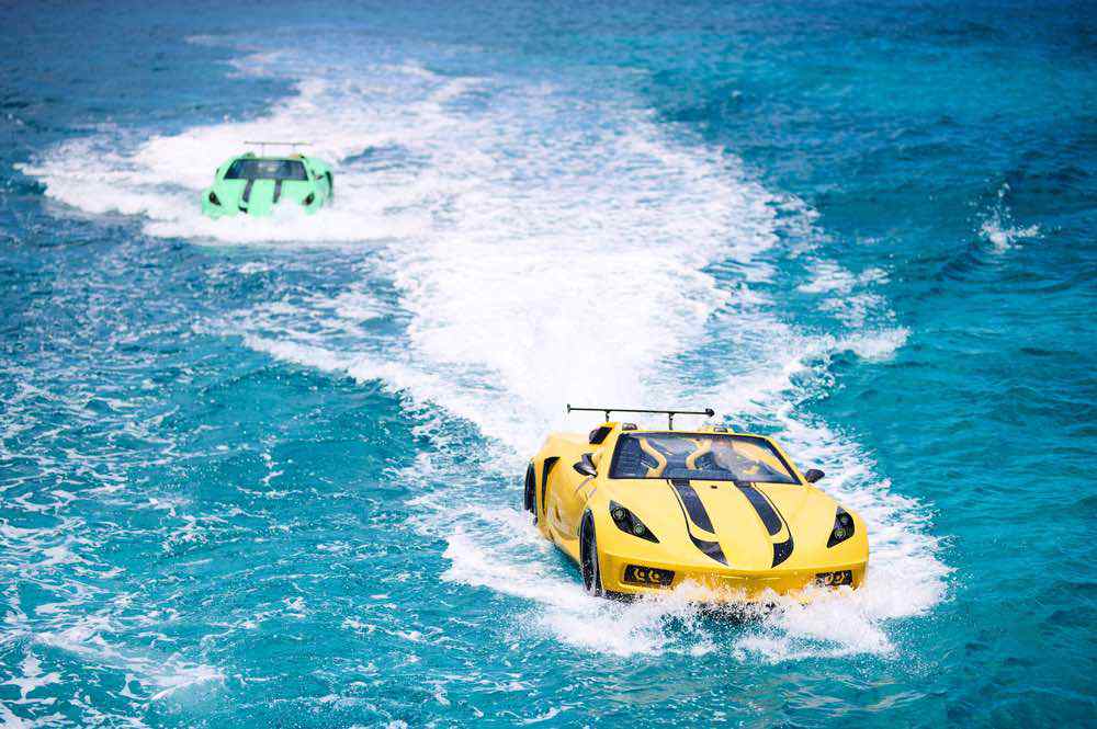 Two sports cars racing on vibrant blue water
