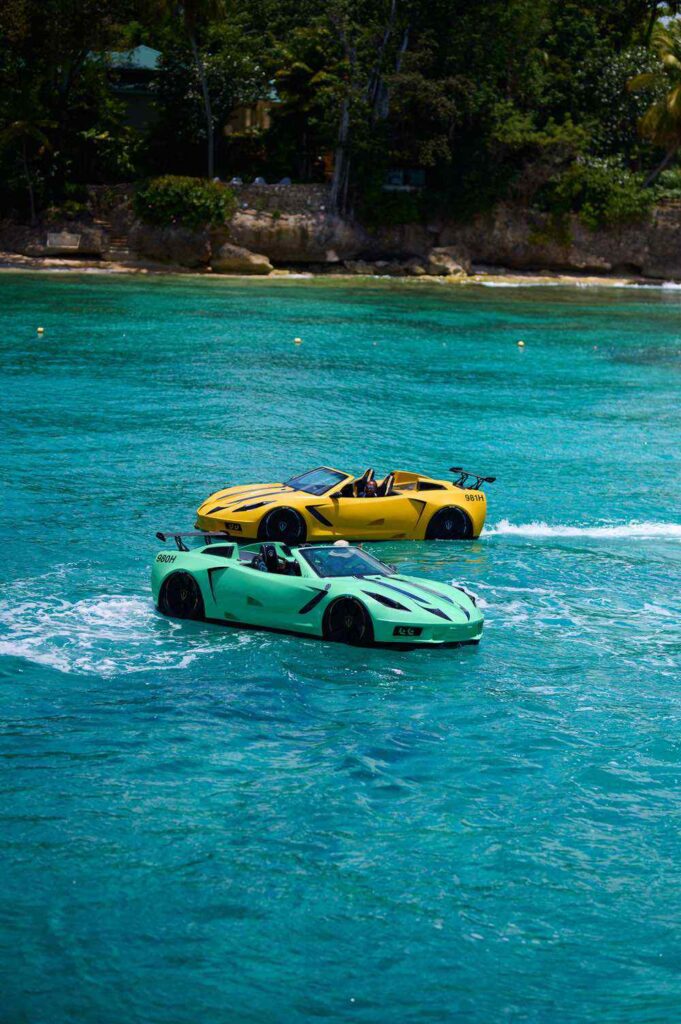 Yellow and green sports cars floating on turquoise sea