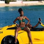 Woman posing on yellow boat in green bikini