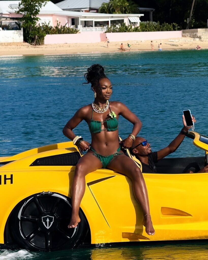 Woman posing on yellow boat in green bikini