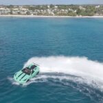 Speedboat creating waves near tropical beachfront