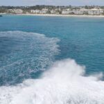 Boat creating wake near tropical coastline