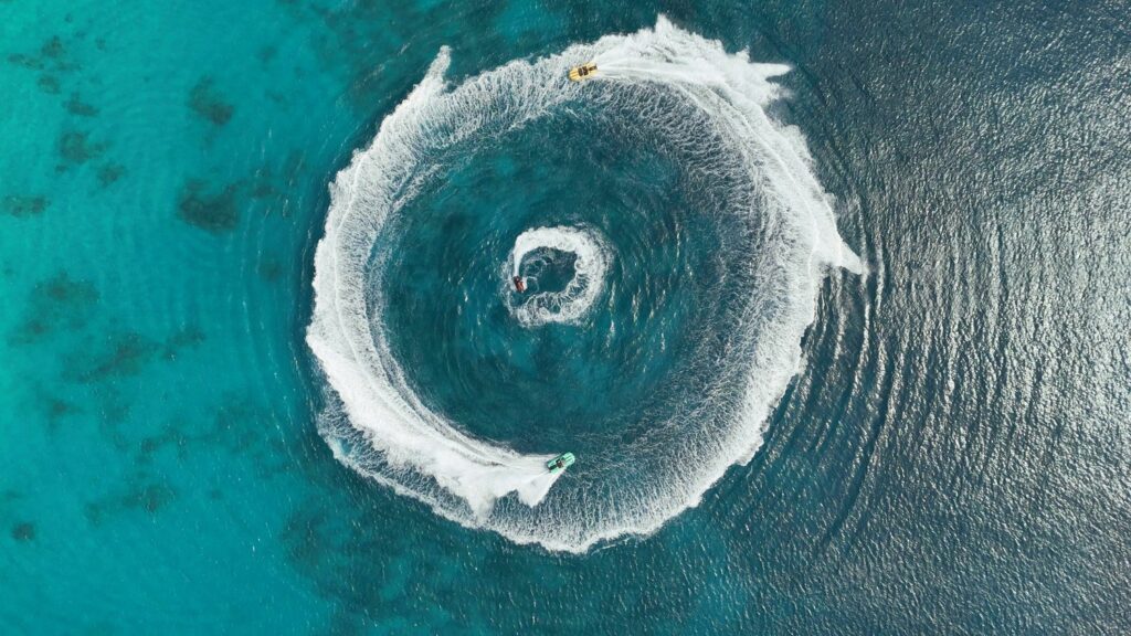 Aerial view of jet skis circling on turquoise water