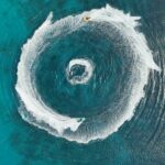 Aerial view of jet skis circling on turquoise water
