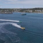Speedboats creating wakes in scenic coastal harbor