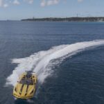Yellow speedboat cruising on blue ocean