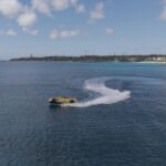 Yellow sports car floating on blue ocean water