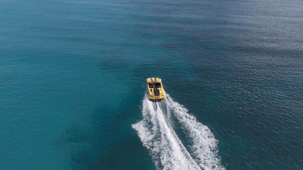 Yellow boat speeding on clear blue ocean